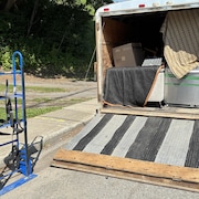 Une remorque de déménagement avec des électroménagers et un sofa.