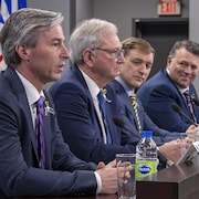 Les quatre premiers ministres sont assis en rang à une longue table. Tim Houston, à gauche complètement, est celui qui parle.