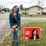 Renée Cable se tient debout à côté de sa pancarte électorale dans son quartier, en septembre 2023. 