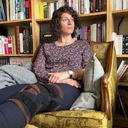 Assise dans son salon, Isabelle Bourgeois a un bandage sur le genou.