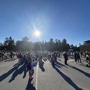 Des jeunes se trouvent dans une cour d'école.