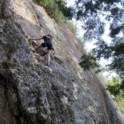 Une jeune fille escalade une parois rocheuse, près des chutes Neigette.