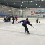 Une joueuse de ringuette participe à un concours d'habileté sur la glace.