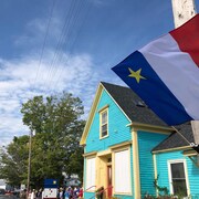 Petite maison bleue et drapeau acadien qui flotte à Riverside-Albert, au Nouveau-Brunswick, le 16 août 2019.