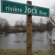 Pancarte devant la rivière Jock, l'automne. 