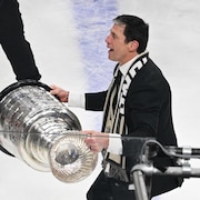 Rod Brind'Amour, l'entraîneur-chef des Hurricanes de la Caroline, brandit la coupe Stanley après la victoire contre les Golden Knights de Vegas lors du sixième match de la finale de la Coupe Stanley de la LNH, dimanche 14 juin 2026, à Las Vegas. 