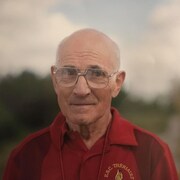 Un homme aux cheveux gris avec des lunettes.