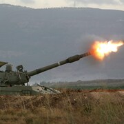 Un char d'assaut tire une roquette.