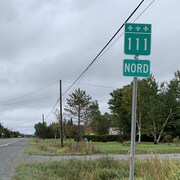 Une route et un panneau qui indique 111 nord.