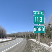 Un panneau indiquant la 113 nord près de la route.
