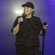 Roxanne Bruneau sourit, un micro à la main. 