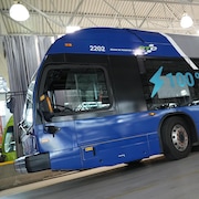 Un autobus électrique dans un grand hangar blanc. 