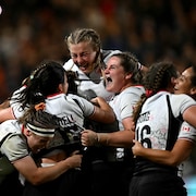 Des joueuses de rugby s'enlacent en fin de match.
