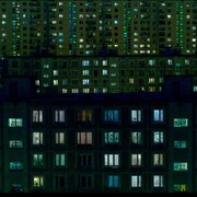 Les fenêtres de nombreux immeubles d'habitation sont éclairées dans la noirceur du soir.