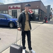 Sahil Kumar dans la rue buvant un café.