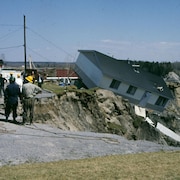 On voit une maison qui est entraînée dans la coulée de boue à Saint-Jean-Vianney.