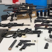 Des armes placées sur des tables. 