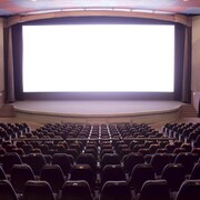 Une salle de cinéma avec un écran blanc en arrière plan.
