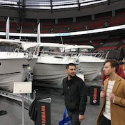 Des gens marchent à côté de bateaux installés au stade BC Place pour le salon nautique de Vancouver.