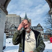 Un homme se prend la tête en plein hiver, dans un campement de fortune d'Halifax. 