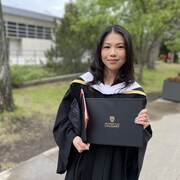 Sarah Chung en toge universitaire tient son dipl&ocirc;me.