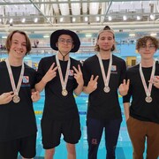 Olivier Legault, Kevin Williamson, James Williamson et Marc-Antoine Bernier, du club Dam'eauclès de Val-d'Or, médailles au cou au bord de la piscine à la suite de leur 2e position au classement par équipe au championnat canadien de sauvetage sportif.