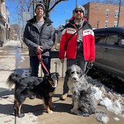 Tyler Schlomb et Mark Rullo sont pris en photos sur la rue avec leur chien.