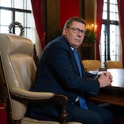 Le premier ministre de la Saskatchewan, Scott Moe, assis dans son bureau. 