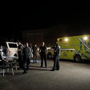 Des ambulanciers et des pompiers sur un quai à Neuville la nuit.