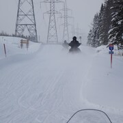 Des motoneigistes sur une piste