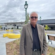 Un homme devant des jeux d'eau et des bancs de parc. 