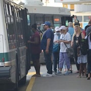 Des gens sont sur le point de monter à bord d'un autobus de transport en commun.