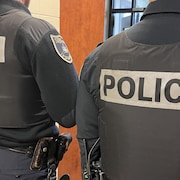 Des policiers de dos en uniforme.