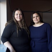 Deux femmes se tiennent sur le bord d'une fenêtre, dans une salle de classe, à Iqaluit, le 2 juin 2023.
