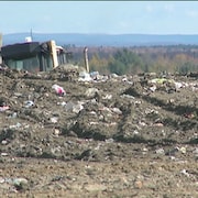 Un camion étale les déchets.