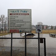 Un skatepark et une pancarte énonçant les règlements.