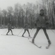 Trois skieurs se suivant en file sur une piste, les skis en pointe de tarte.