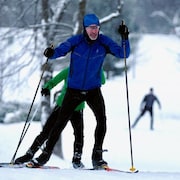 Deux personnes grimpent une pente en ski de fond.
