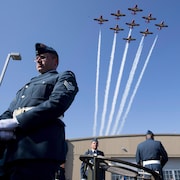 Des avions volent au-dessus des têtes de nombreux militaires.