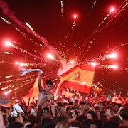 Un feu d'artifice explose derri&egrave;re une foule en liesse.