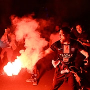 Un partisan brandit une fusée de détresse rouge à Paris.