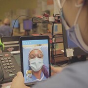 Des membres du personnel de santé communiquent via des tablettes électroniques.