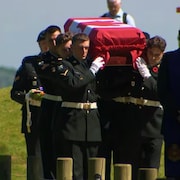 Des militaires transportent un cercueil. 
