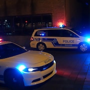 Des voitures de police avec les gyrophares allumés. 