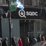 Des gens en file devant une succursale de la SQDC à Montréal.