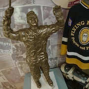 Une statue et un chandail de hockey des Flying Fathers.