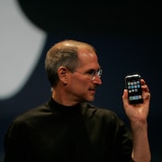 Steve Jobs avec un iPhone en main