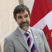 Portrait de Steven Guilbeault devant un drapeau canadien.