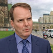 Steven MacKinnon en entrevue sur la colline du Parlement à l'extérieur devant la pelouse.