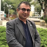 Sultan Ali Sadat souriant et debout dans un parc.